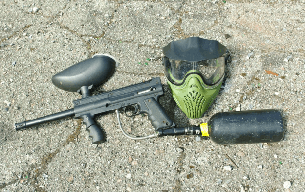paintball gun and mask on asphalt